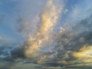 Obraz premium Beautiful cloudy sunset sky with blue and yellow tones.