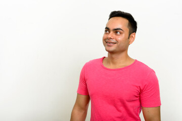 Portrait of happy young handsome Indian man thinking