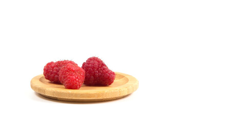 Ripe tasty bright Fresh raspberry in a wicker basket on a cutting board