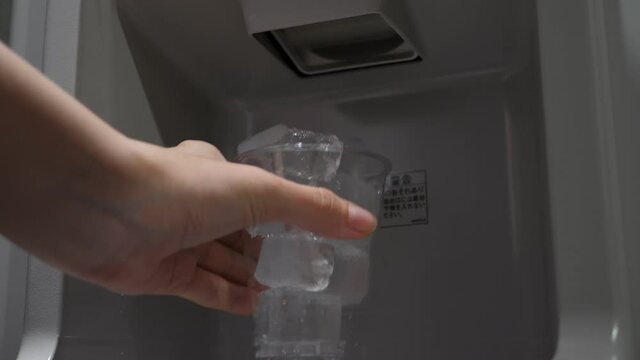 Ice cubes fall down from dispenser to empty plastic cup, which is quickly filled up and overflow. New cubes does not fit, spillover brim and fall down on floor