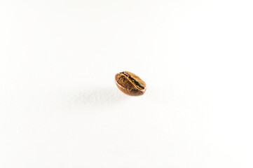 Closeup of a single roasted coffee bean, isolated on a white background