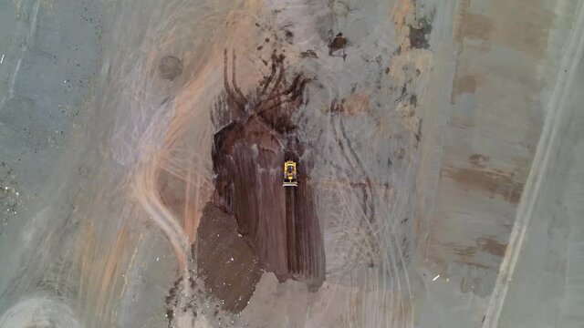 Earth mover. heavy duty machinery working at landfill trash dump. Bulldozer, dumper truck, soil compactor roller. Drone aerial shot 4k. 
