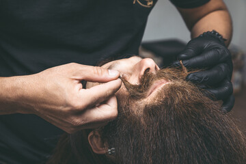 Barber cutting a man's mustache