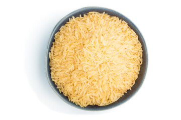 Blue ceramic bowl with raw golden rice isolated on white background. Top view.