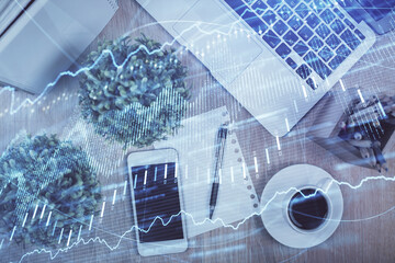 Multi exposure of financial chart hologram over desktop with phone. Top view. Mobile trade platform concept.
