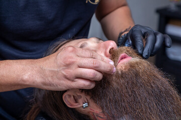 Barber cutting a man's mustache