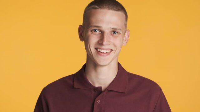 Portrait of young attractive positive man happily smiling on camera over colorful background. Happy expression