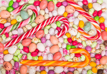 Colorful multicolored candies on a white wooden background. close up, top view.
