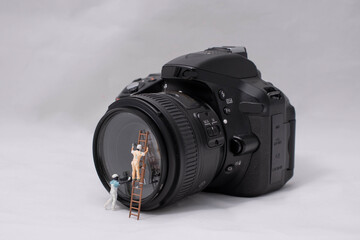 Miniature window washers clean a digital camera lens.