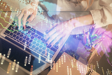 Double exposure of woman hands typing on computer and forex chart hologram drawing. Stock market invest concept.