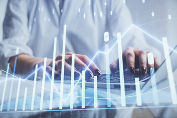 Double exposure of woman hands typing on computer and forex chart hologram drawing. Stock market invest concept.