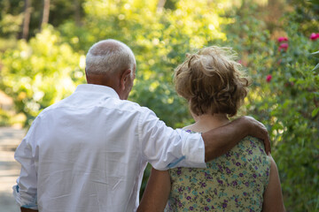 senior couple walking embraced outdoors