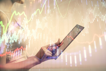 Double exposure of forex chart sketch hologram and woman holding and using a mobile device....