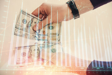 Multi exposure of financial graph drawing hologram and USA dollars bills and man hands. Analysis concept.