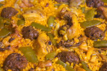 Closeup of a paella with meat, vegetables and meatballs