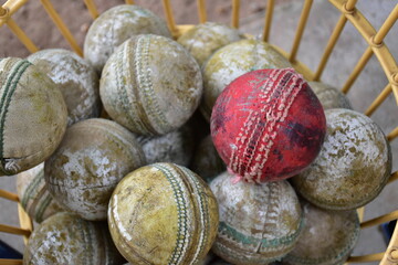 Used balls of cricket sport kept in basket.