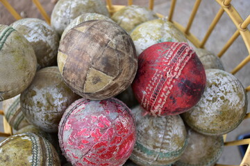 Used balls of cricket sport kept in basket.