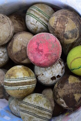 Used balls of cricket sport kept in basket.