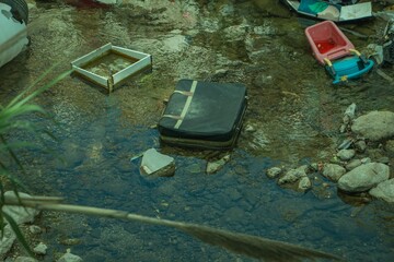 Waste and garbage thrown into the river. Water pollution and plastic garbage in the river