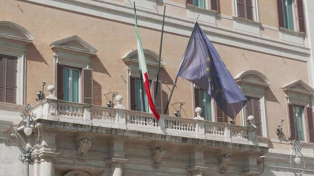 Italian and European Flag at Montecitorio Palace, italian Parliament. Policemen with masks at the entrance. Rome, Italy. July 30, 2020