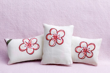 White flowered  cushions on pink sofa