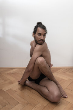 A young Afro European male Yogi does meditation and Hatha Yoga workout at home during lockdown.