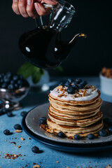 Stack of pancakes with fresh blueberry and maple syrup
