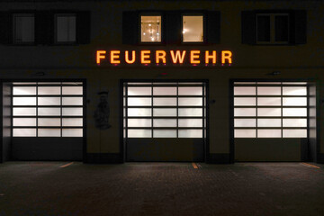 Rolltore eines Feuerwehrhauses bei Nacht.