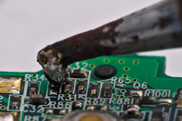 
Soldering iron and circuit board macro photograph. Science and technology themes