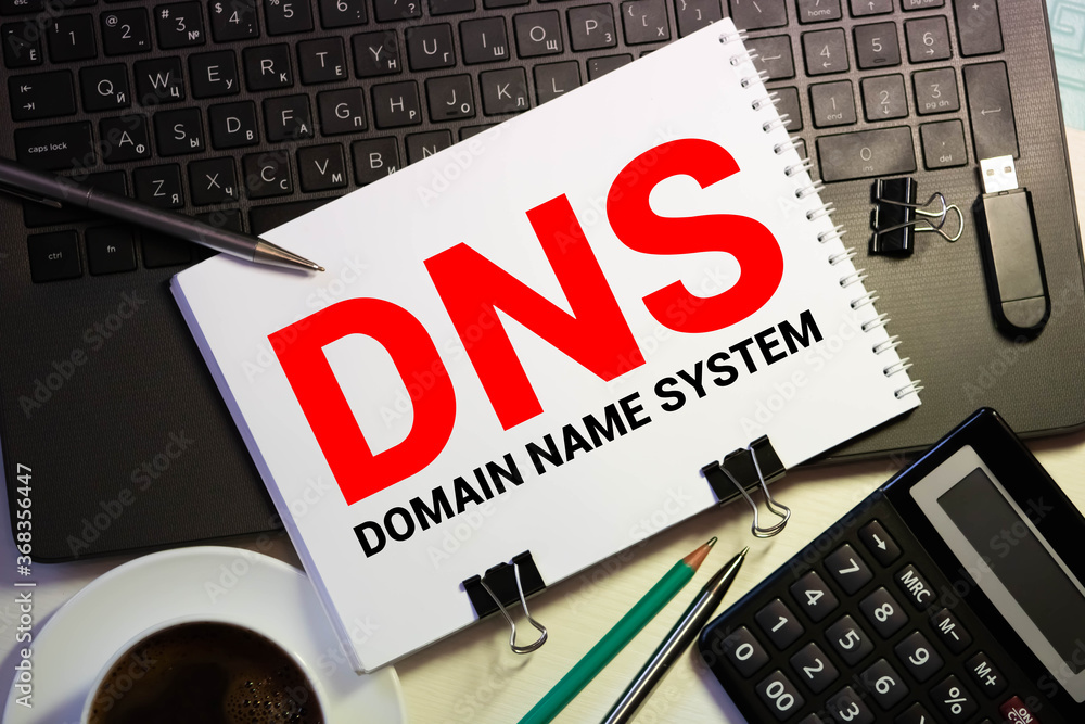 Poster dns- domain name system written in notebook on wooden background