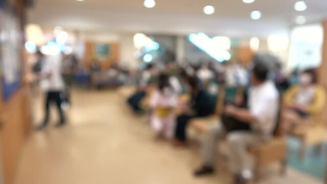 マスクを付けた患者で混み合う病院のロビー  ぼかし背景素材 ソーシャルディスタンス 新しい生活様式  4K / Blurred shot of patients with mask waiting in the crowded lobby at hospital in Japan. Social distancing. 4K
