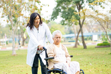 Fototapeta premium Doctor help and care Asian senior or elderly old lady woman patient sitting on wheelchair at nursing hospital ward, healthy strong medical concept