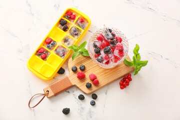 Ice and frozen berries on white background