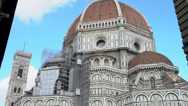 Cattedrale di Santa Maria del Fiore In Florence, Italy. Front View Of The Cathedral of Saint Mary of the Flower At Daytime With Blue Sky In The Background. - panning up