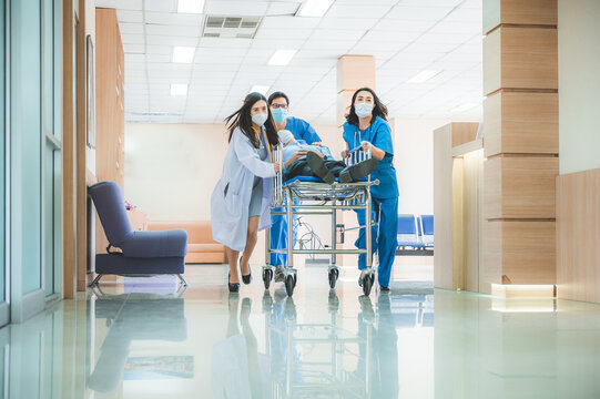 Emergency department, doctors and surgeons team move seriously injured patient lying on a stretcher through hospital corridors. medical staff in a hurry Move patient into operating room