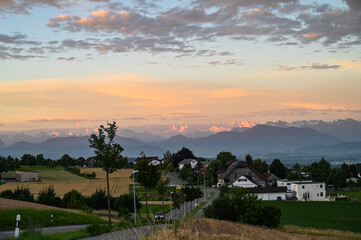 Fototapeta na wymiar Sunset over small Swiss village and the Alps