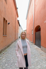 Young beautiful blonde woman along the alley in the city