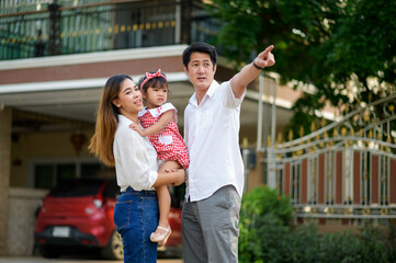 Beautiful family portrait smiling outside their new house with sunset