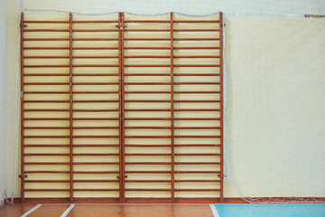 Swedish wall in the school gym. Wooden stairs for gymnastic exercises in sports lessons in College
