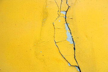 Yellow wall with cracks. Cracked wall.