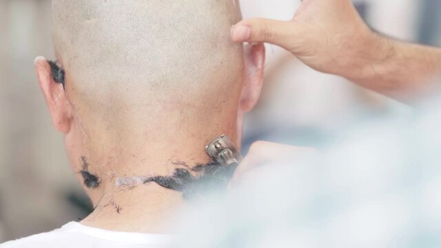 A man shaves his head for ordination.