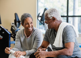 happy senior couple exercising in gym