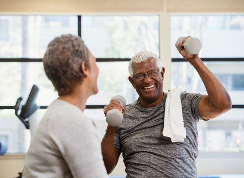 happy senior couple exercising in gym