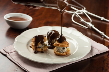 chocolate cream and cocoa profiteroles with hot melted dripping topping