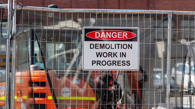 Danger, demolition work in progress sign in a real construction site. 