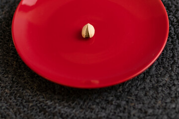 Raw organic pistachio nuts presented on a red plate
