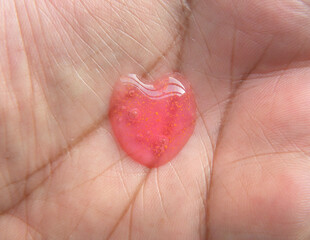 Fototapeta premium Dollop of red color heart shape body wash gel on palm of hand