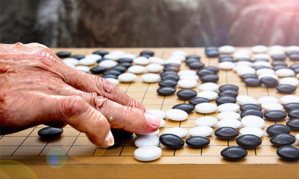 a hand playing a game of go