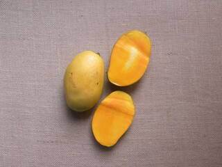Whole and cut yellow color ripe fresh Mallika mangoes