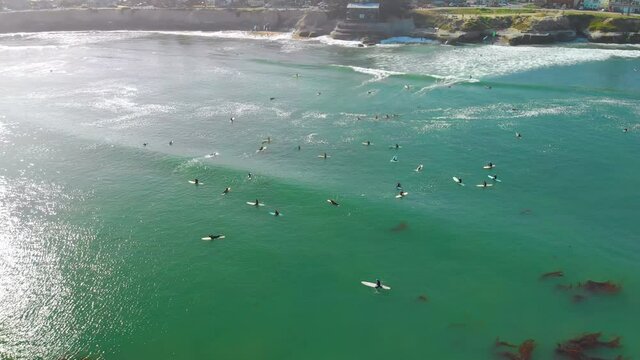 Aerial Rotation Around Surfers Waiting for Waves on Green Ocean